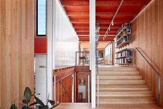 Stairs lead up to an office space lined with bookshelves.