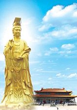 Photograph of an impressively tall, gold statue of a Chinese goddess clothed in flowing robes.