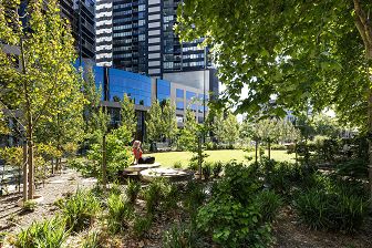 Lawn space and seating provide respite in the urban area. Artistic play ground swings. View of Southbank from tram tracks. Artistic playground slides.