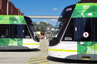 Side angle shot of two trams about to cross in front of each other. The front tram is coming from the right, while the back tram is coming from the left
