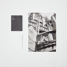 A book cover lies next to a poster foldout featuring photographs of building details.