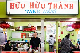 A man stands in front of his noodle and congee stall.