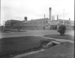 A black and white image of an industrial brick complex with signs saying Barnett Glass Rubber Company.