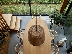Detail image looking down from above into the double-height room with stair detail and feature wicker light pendant