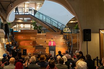 A speaker at a podium in our Foyer, part of our grand opening.