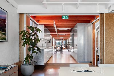 Interior of an office with timber floors and an orange wood beam ceiling.