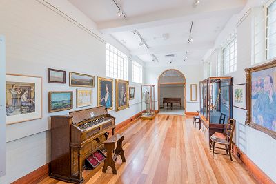 Photograph of Grainger Museum Collection items such as paintings, instruments, clothing and furniture displayed for the Grainger Amplified exhibition