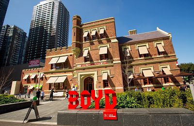 Exterior of a three-level red brick building with shaded windows. The word BOYD is spelled in large red letters at the street interface.