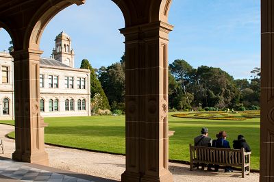 Three visitors sit on a park bench overlooking the Parterre garden