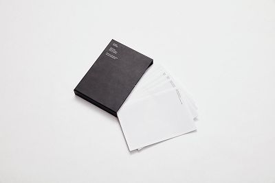 Editions of the Among Buildings publication spill from a book cover.