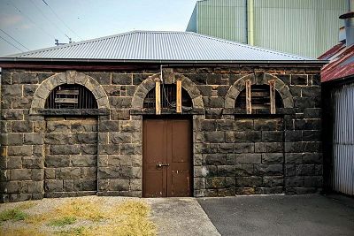 Colour photograph of the bluestone arched entrance to a single-storey, Georgian-style building.
